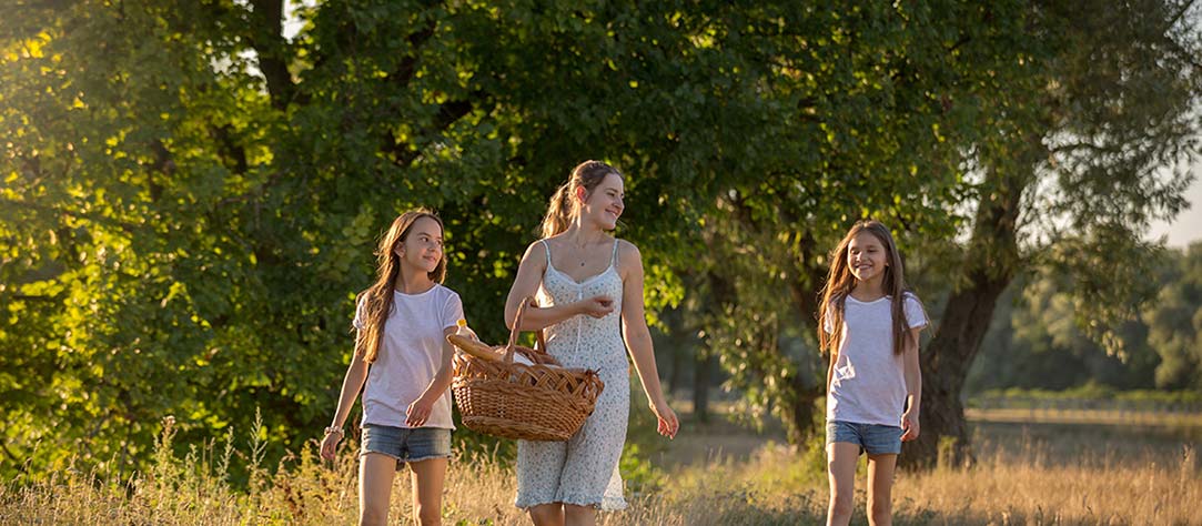 Happy mother walking with daughters outside